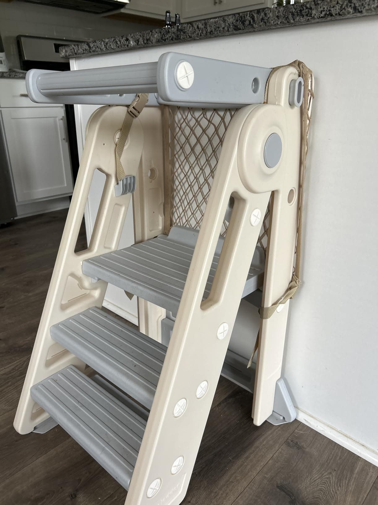 The Olympe Learning Tower, folded with the SafetyNet fitted, in a family kitchen