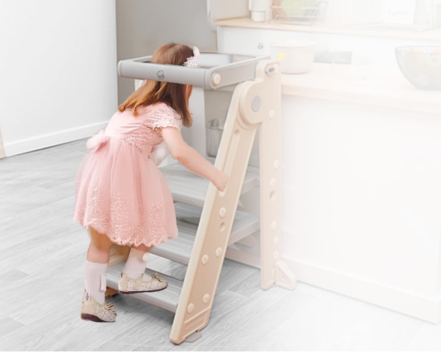 A child stepping up into the Olympe Learning Tower at the kitchen counter
