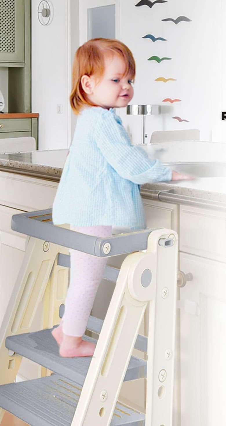 A toddler standing safely in the Olympe Learning Tower at the counter